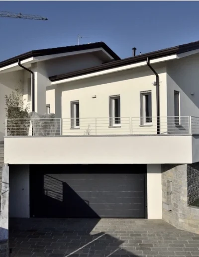 Villetta contemporanea con portico e tetto inclinato, intervento di costruzione o ampliamento edilizio.