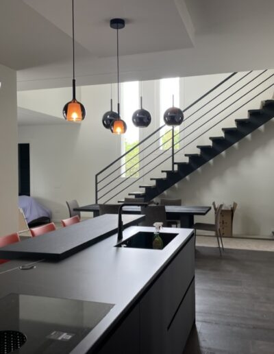 Interno abitazione ristrutturata con cucina contemporanea e scala moderna a giorno.