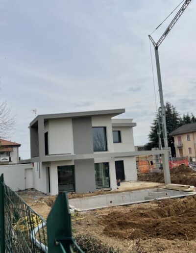 Villetta in fase di costruzione con scavi e struttura in elevazione, lavori edili in corso su edificio residenziale.