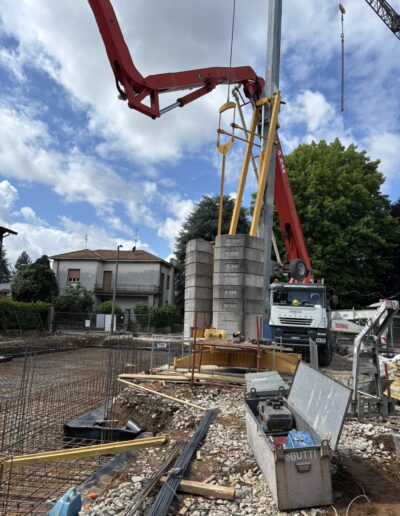 Lavori di realizzazione fondazioni in cemento armato con casseri e armature metalliche, fase strutturale di edificio in costruzione.