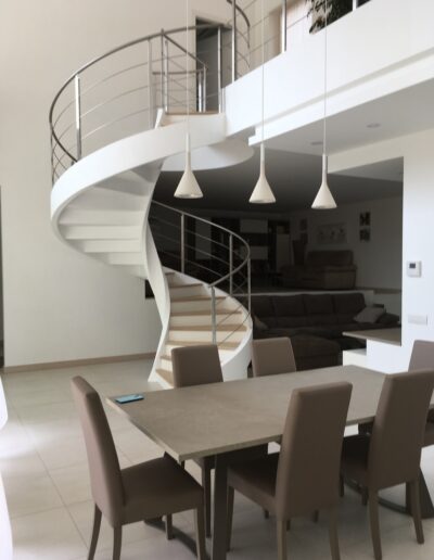 Scala elicoidale bianca dal design moderno all’interno di abitazione ristrutturata con finiture contemporanee.