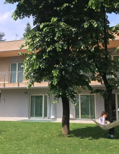 Abitazione unifamiliare con giardino e portico, esempio di nuova costruzione residenziale ultimata.