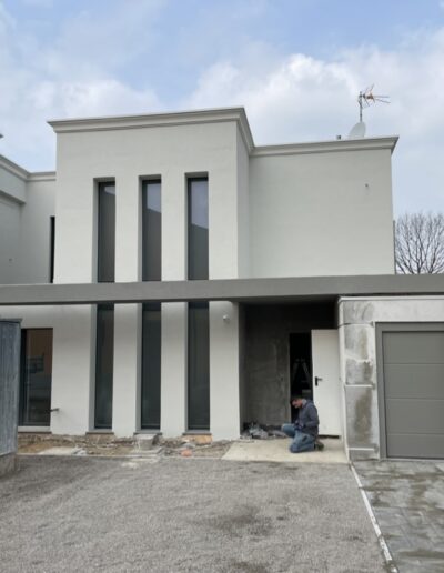 Abitazione moderna con giardino e recinzione metallica, esempio di nuova costruzione completata.