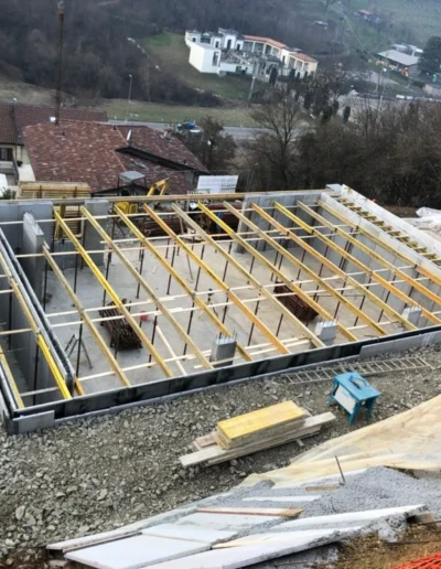 Struttura portante di tetto in legno con travi e orditura installate, fase di realizzazione copertura abitazione.