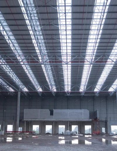 Interno di capannone industriale con struttura metallica e copertura in pannelli, esempio di costruzione per uso produttivo.