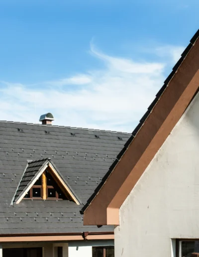 Copertura inclinata con tegole in ardesia grigia, esempio di rifacimento tetto con materiali resistenti e durevoli.