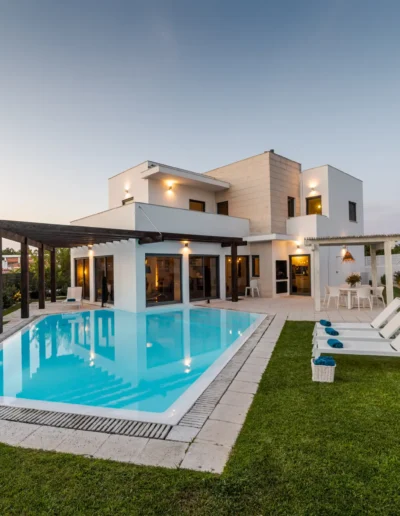 Casa unifamiliare di nuova costruzione con piscina e giardino curato, esempio di realizzazione residenziale di alto livello.