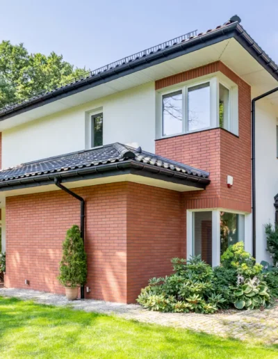 Abitazione con rivestimento esterno in mattoni faccia a vista e dettagli moderni, intervento di costruzione o ristrutturazione.